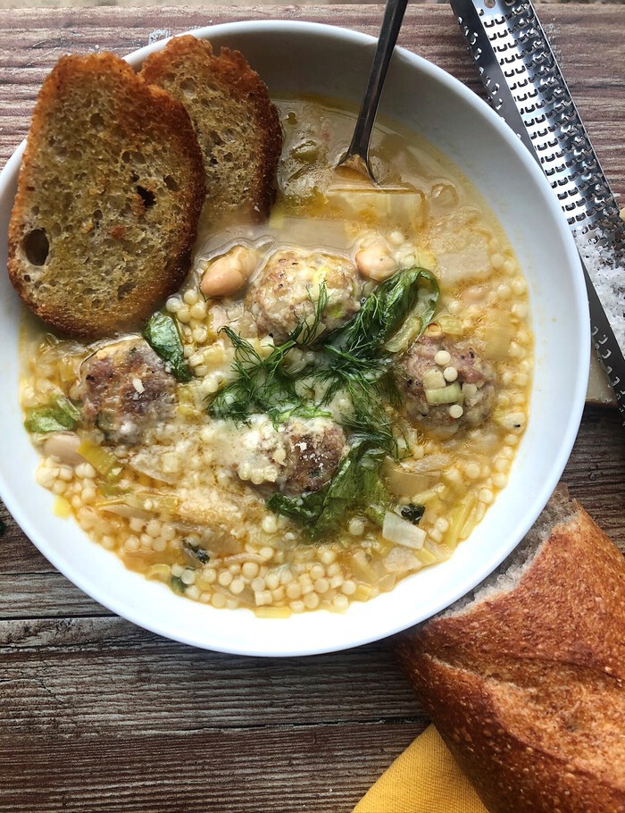 Bowl of Italian wedding soup with bread 