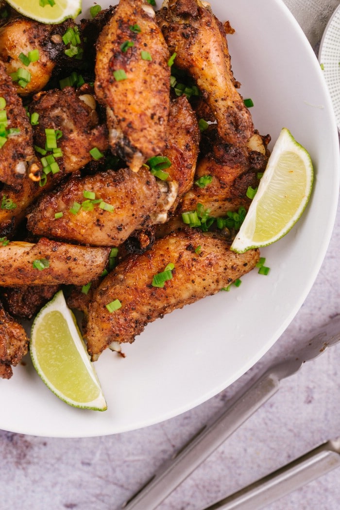 White bowl of chicken wings with lime