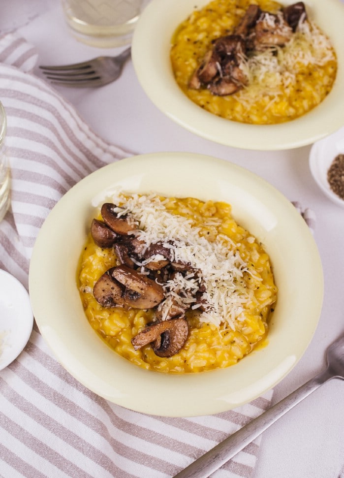 Two bowls of risotto with mushrooms and parmesan