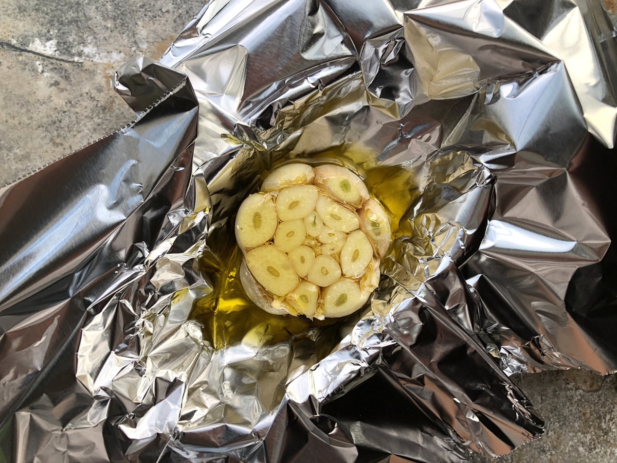 Head of garlic wrapped in aluminum foil