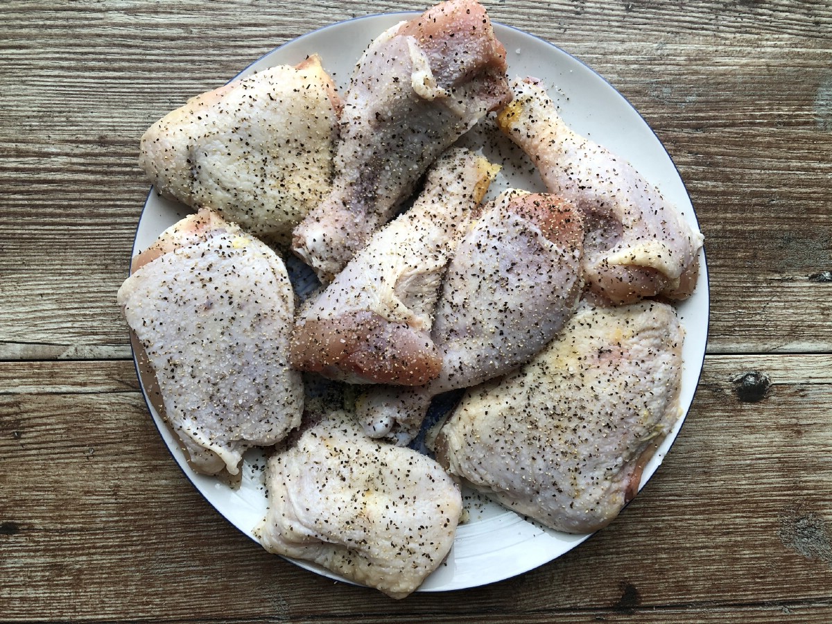 Seasoned raw chicken on white plate