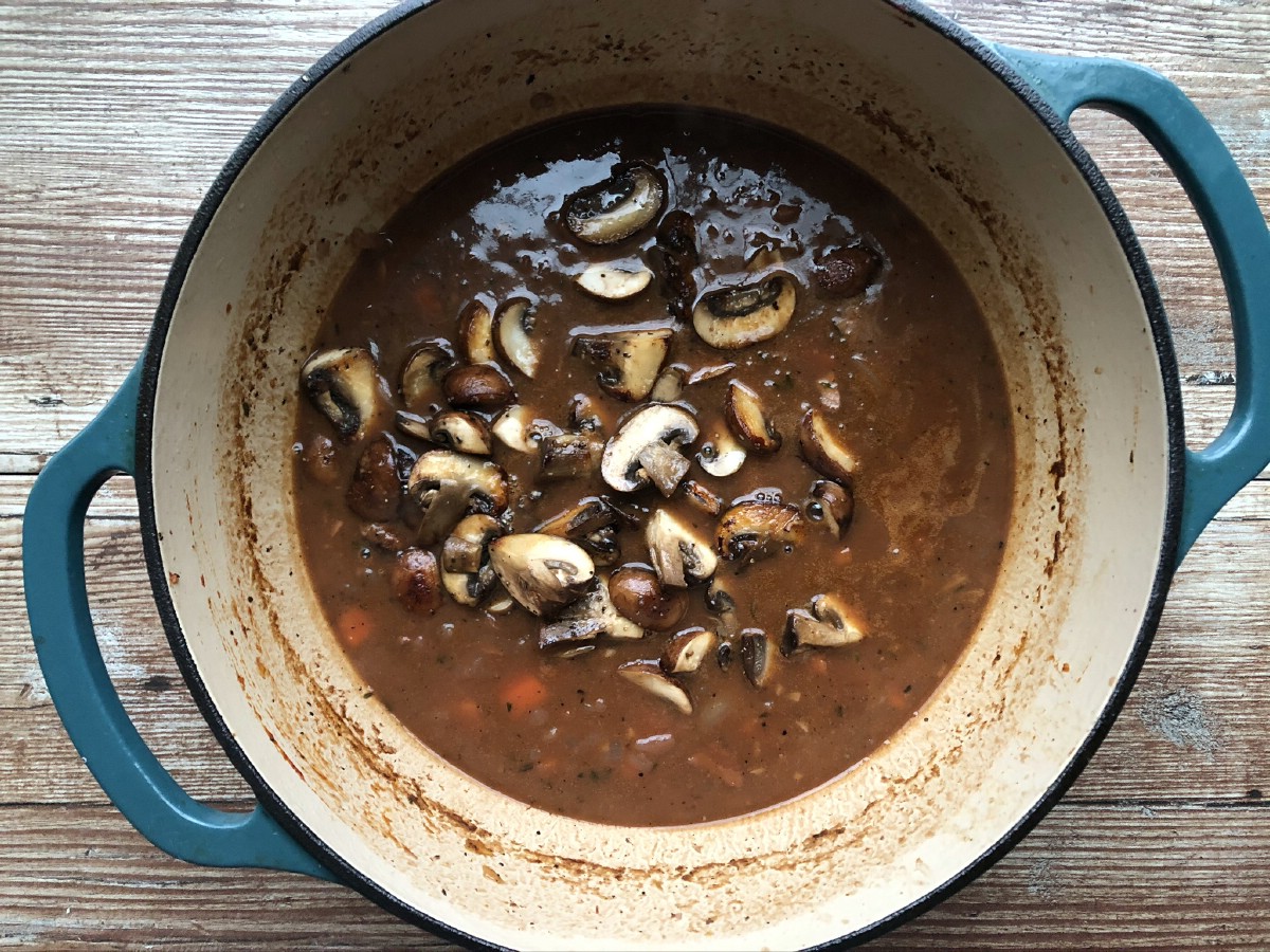 Mixing mushrooms into roux and broth