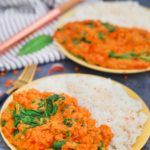 Two plates of red lentil curry and rice