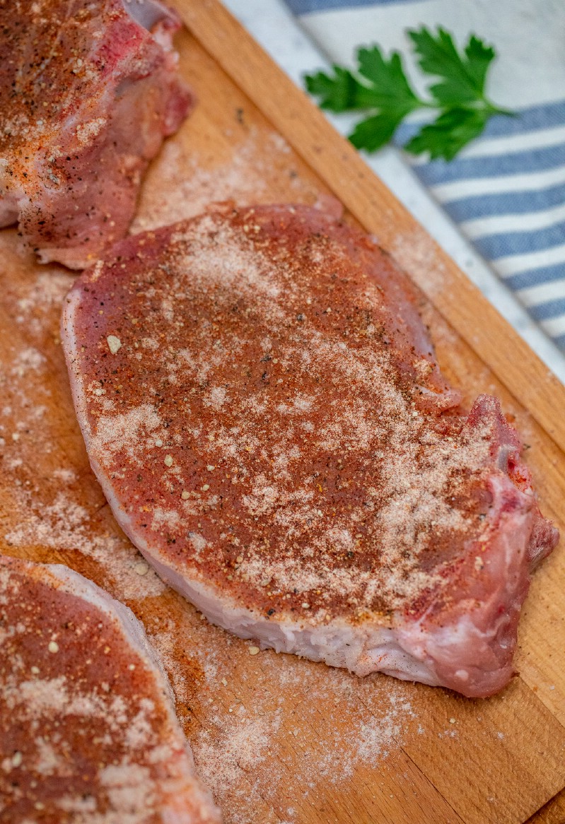 Seasoned pork chops on cutting board