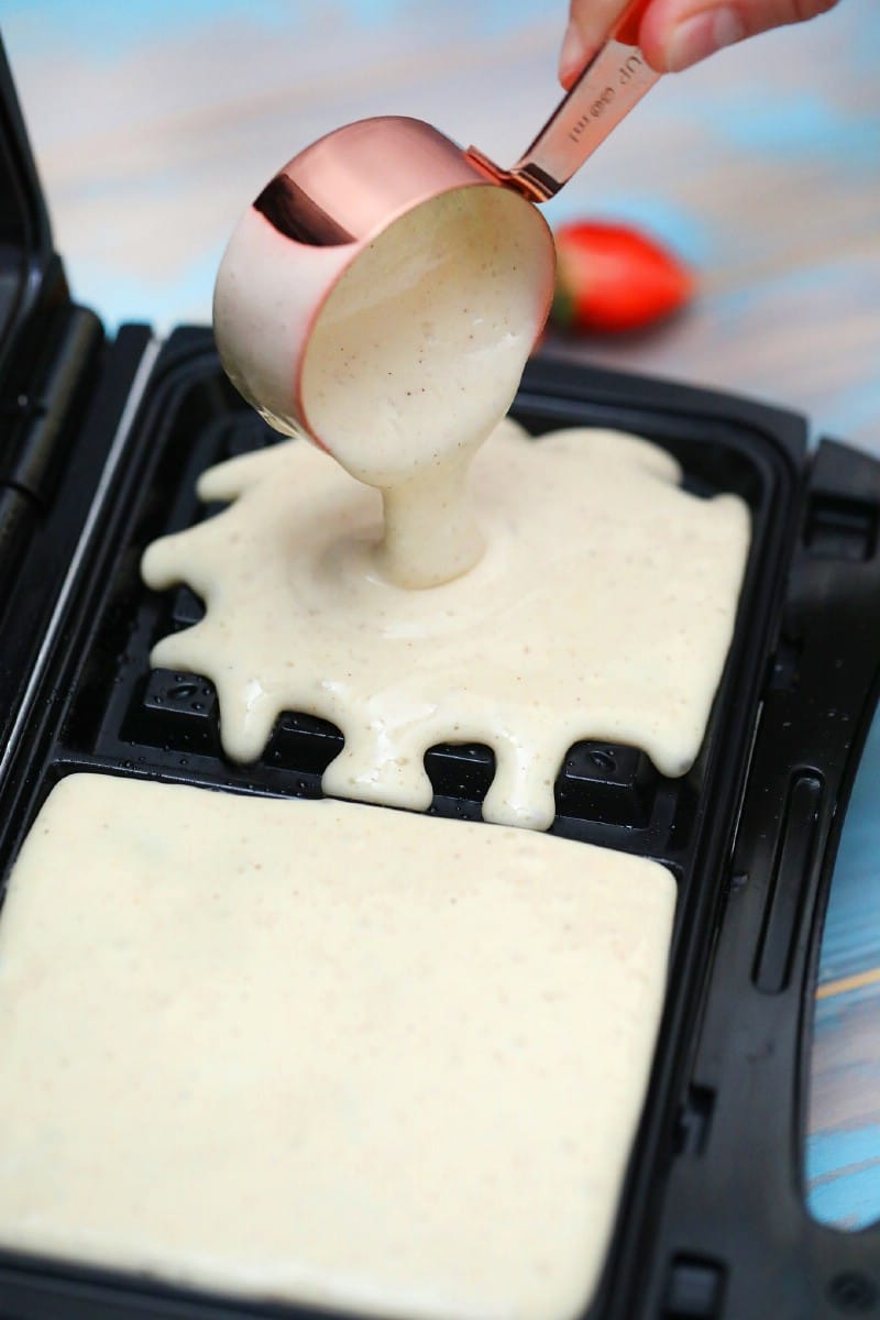 Pouring waffle batter into waffle maker