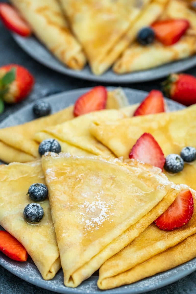 Crepes on a blue plate with berries