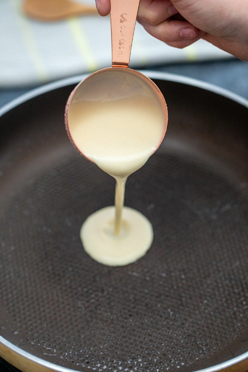 Pouring crepe batter into pan