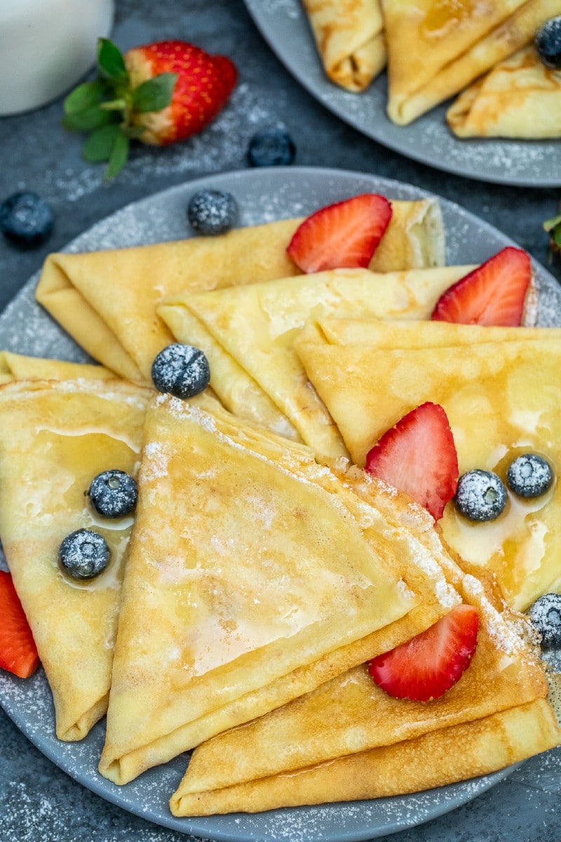 Crepes on a blue plate with berries