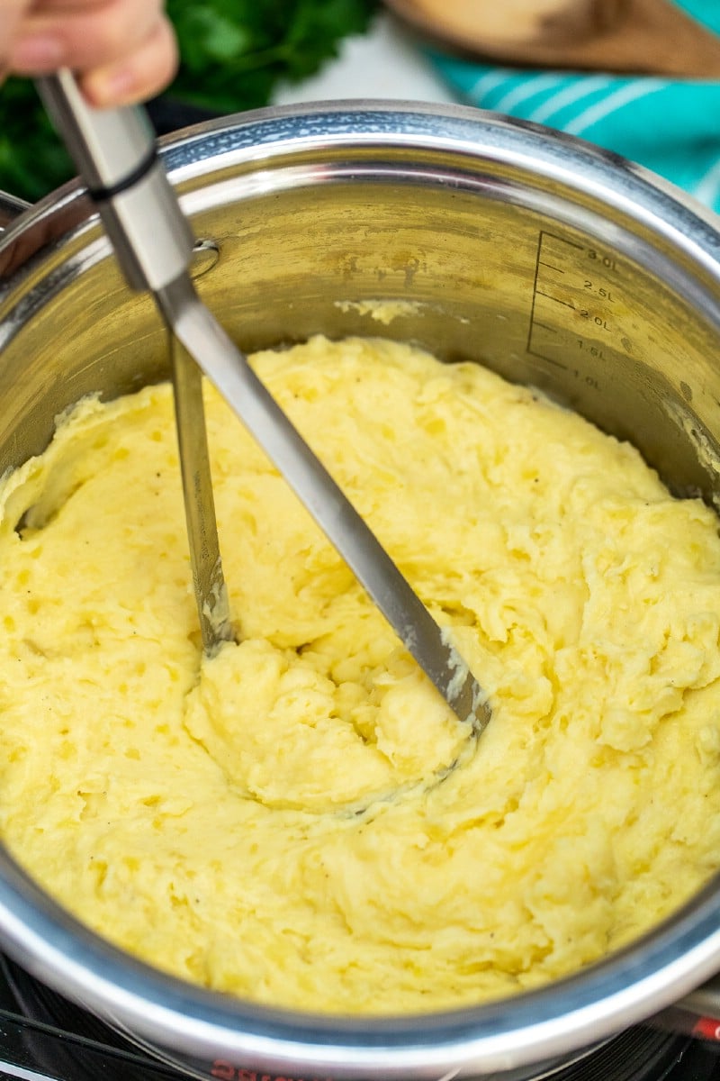 Mashing potatoes in large pan