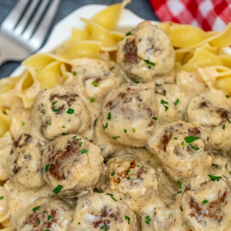 Plate of noodles with swedish meatballs and red checked napkin