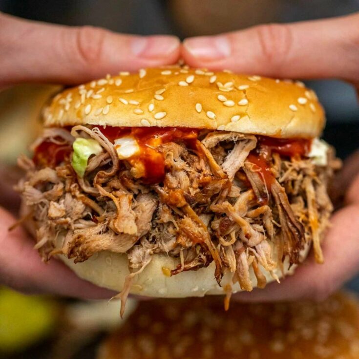 Woman holding pulled pork sandwich