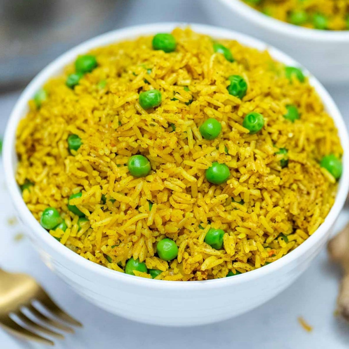 White bowl of Indian rice with peas