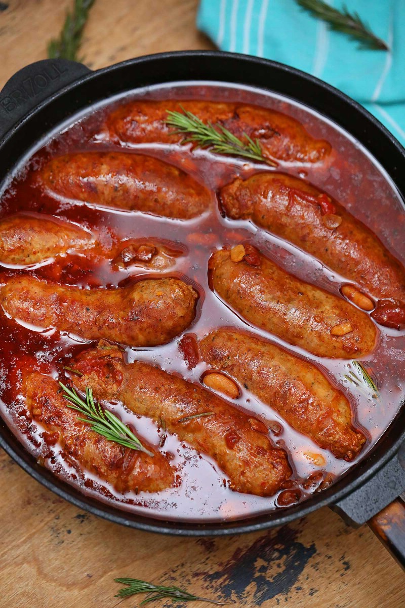 Sausages simmering in cast iron skillet
