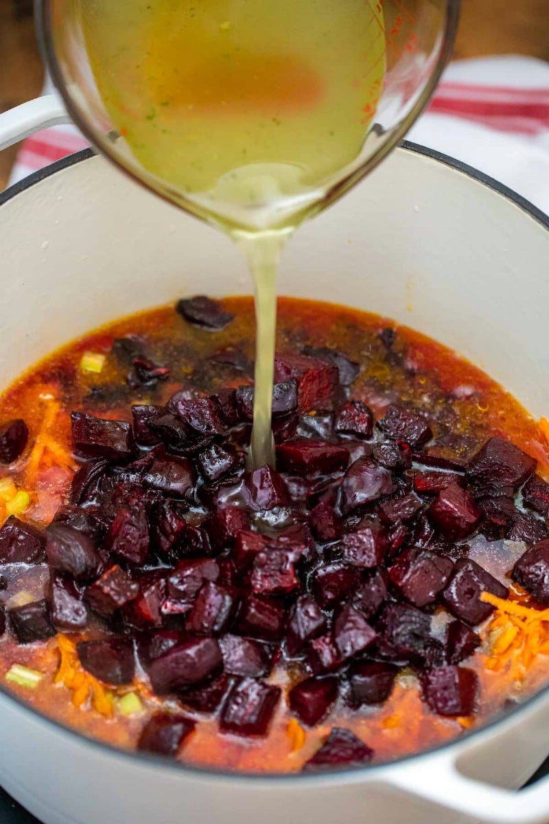 Pouring broth in beet soup