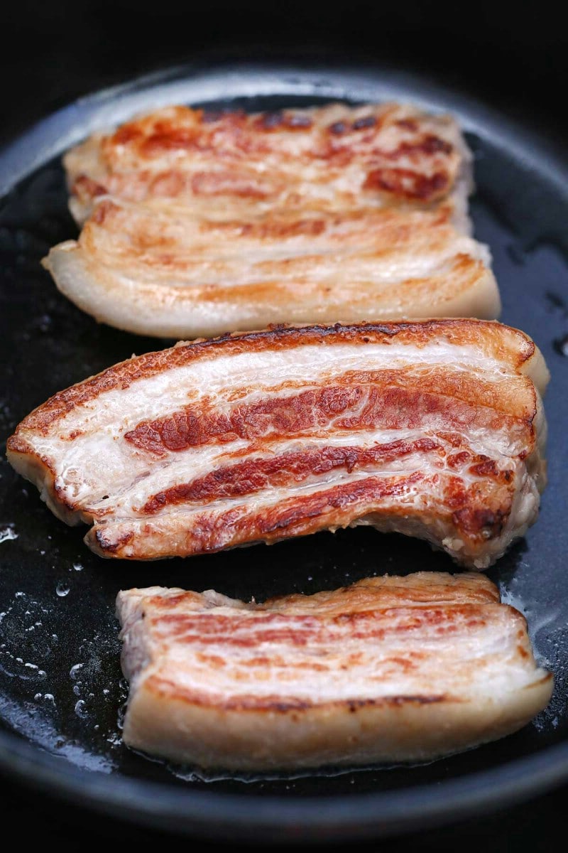 Searing pork belly in a cast iron skillet