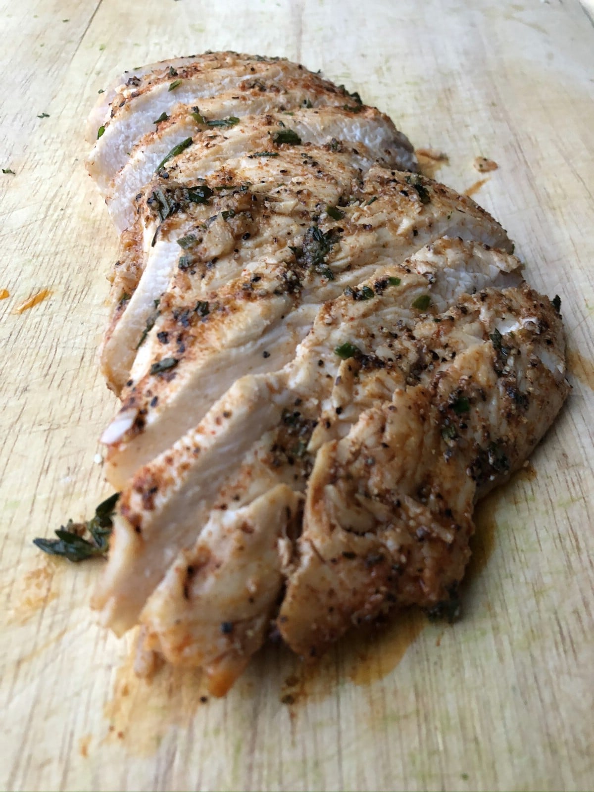 Sliced cooked chicken on cutting board