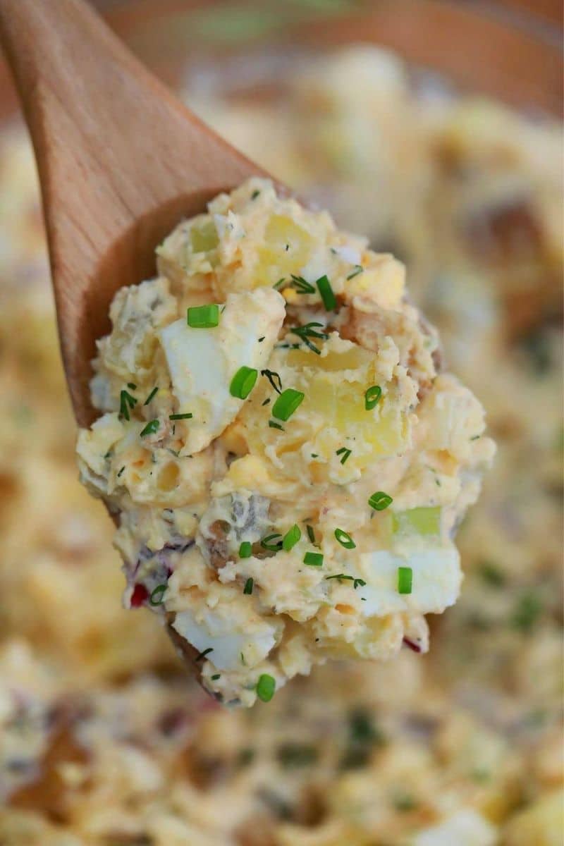 Wooden spoon of potato salad