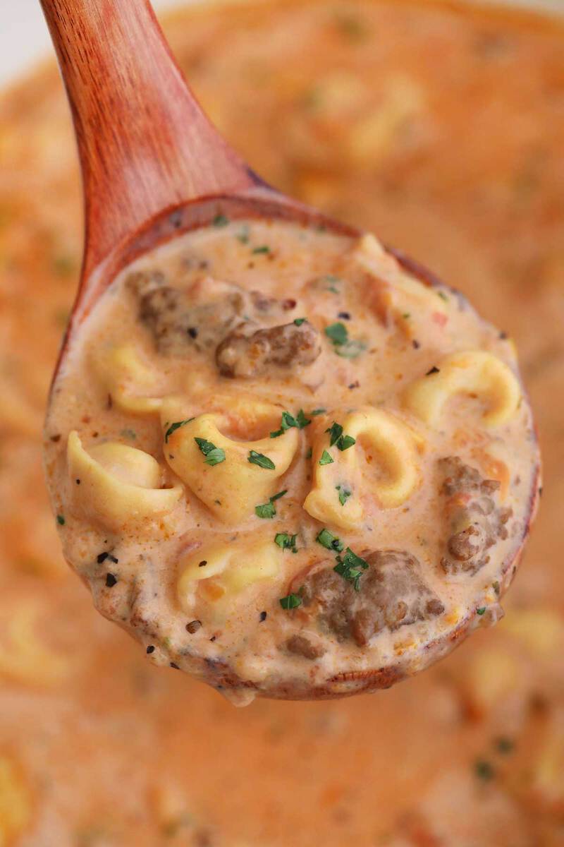 Wooden spoon of sausage tortellini soup