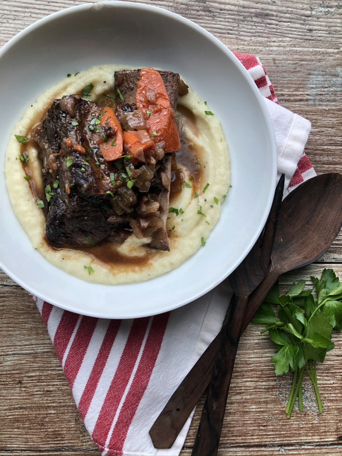 Braised short ribs on parsnip puree in white bowl