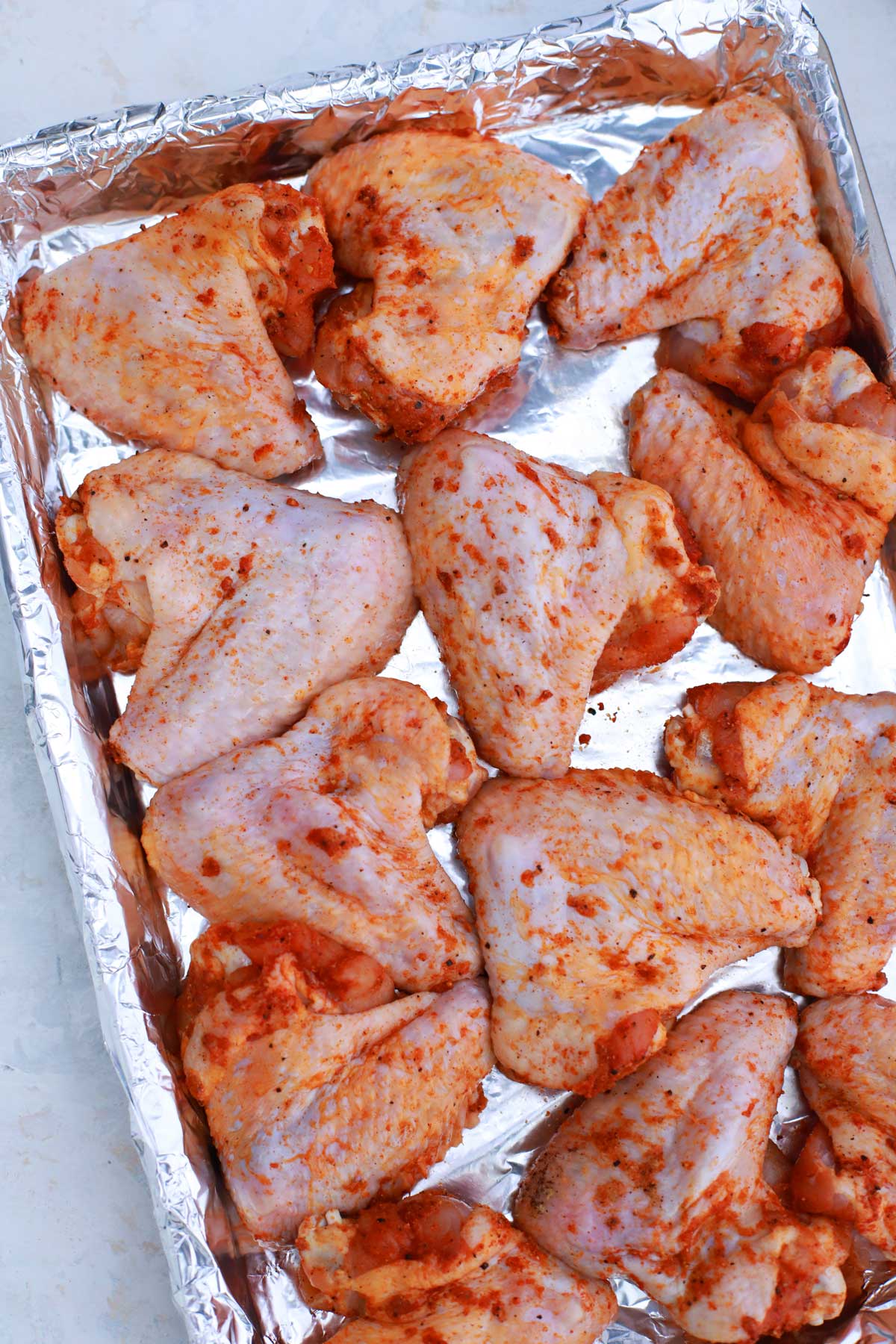 Seasoned chicken wings on baking sheet