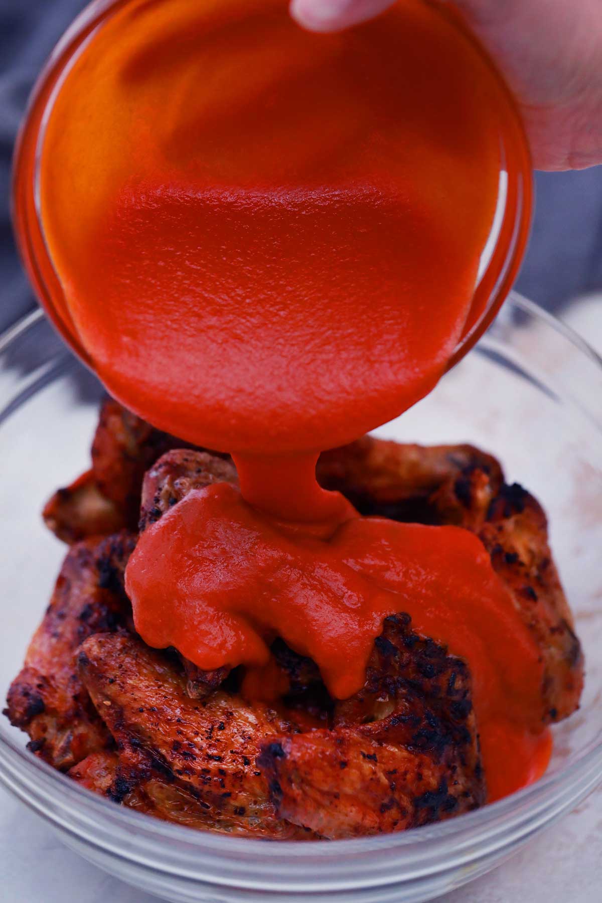 Pouring sauce on wings