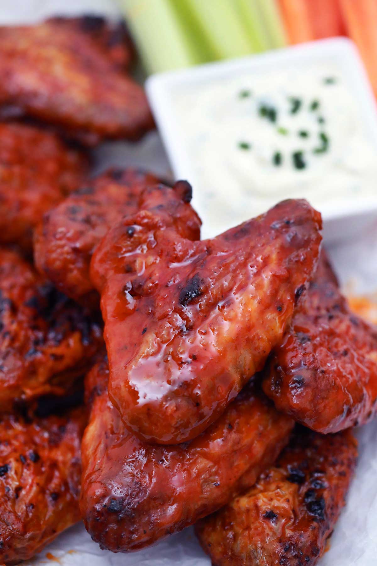 Buffalo chicken wings on white plate with dip