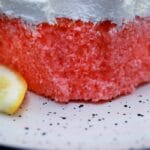 Slice of pink lemonade cake on white plate