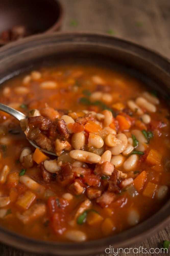 Spoon of bean soup over bowl