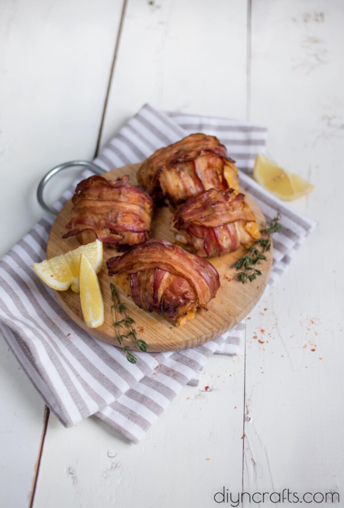 Bacon wrapped chicken on wood platter