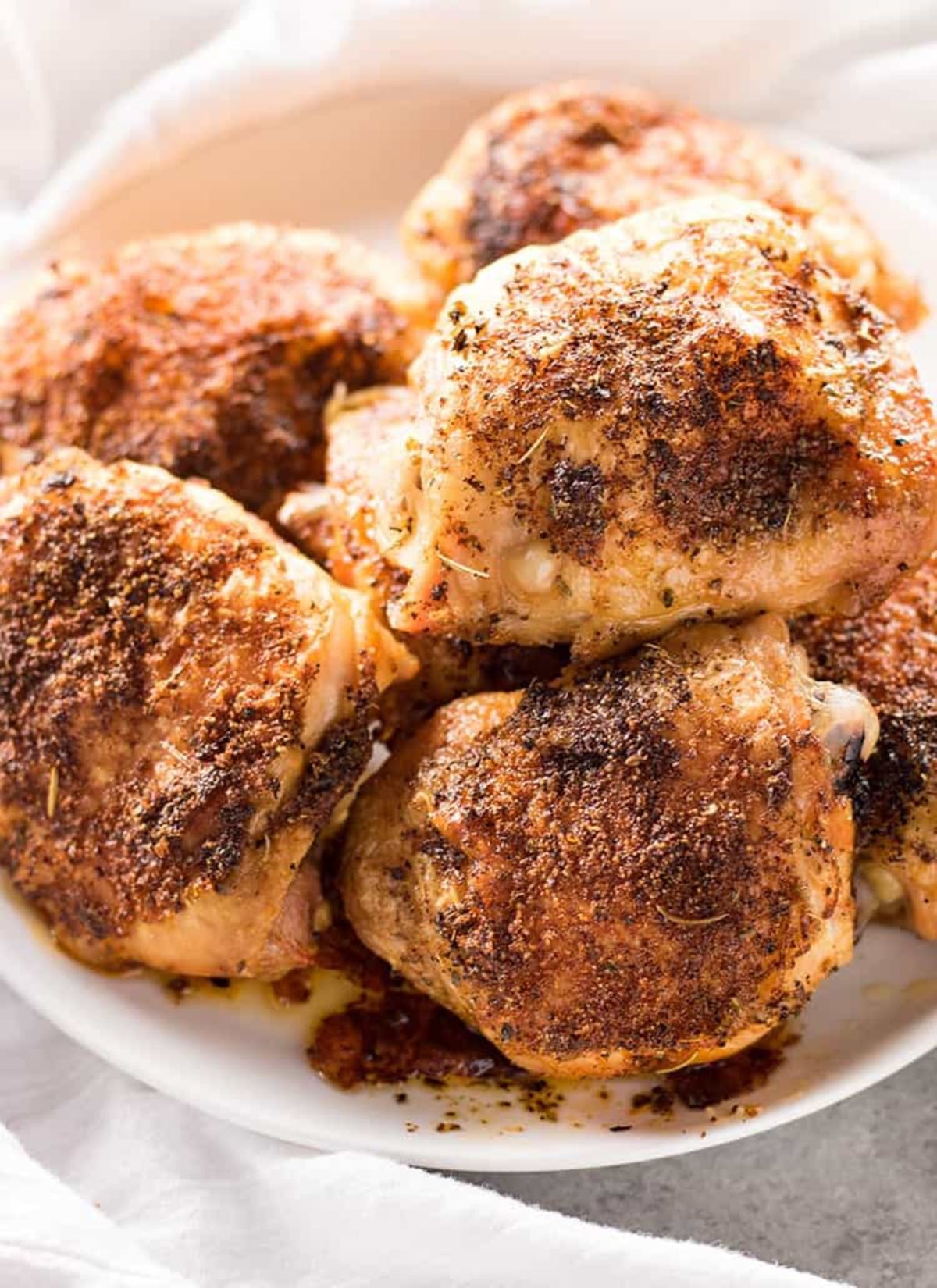 Chicken thighs stacked in white bowl