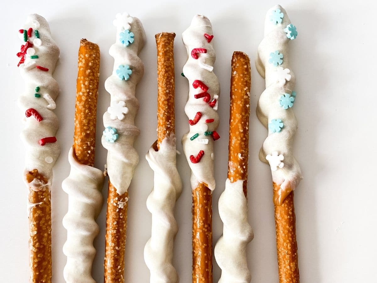 Dipped Pretzel Rods With A Caramel Twist garnished with sprinkles