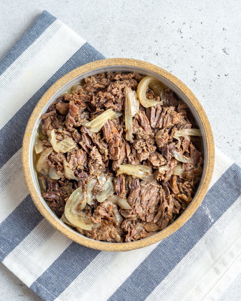 Shredded beef in bowl with onions