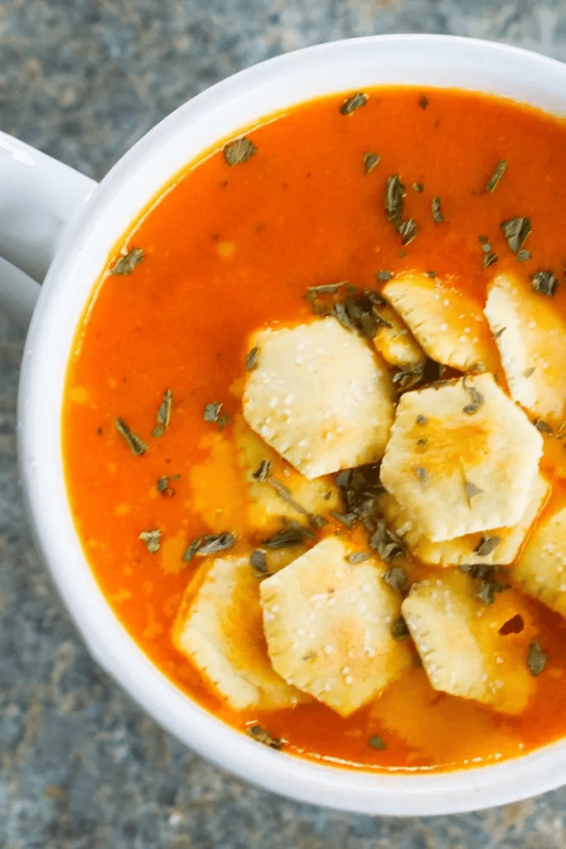 Tomato soup in mug with crackers