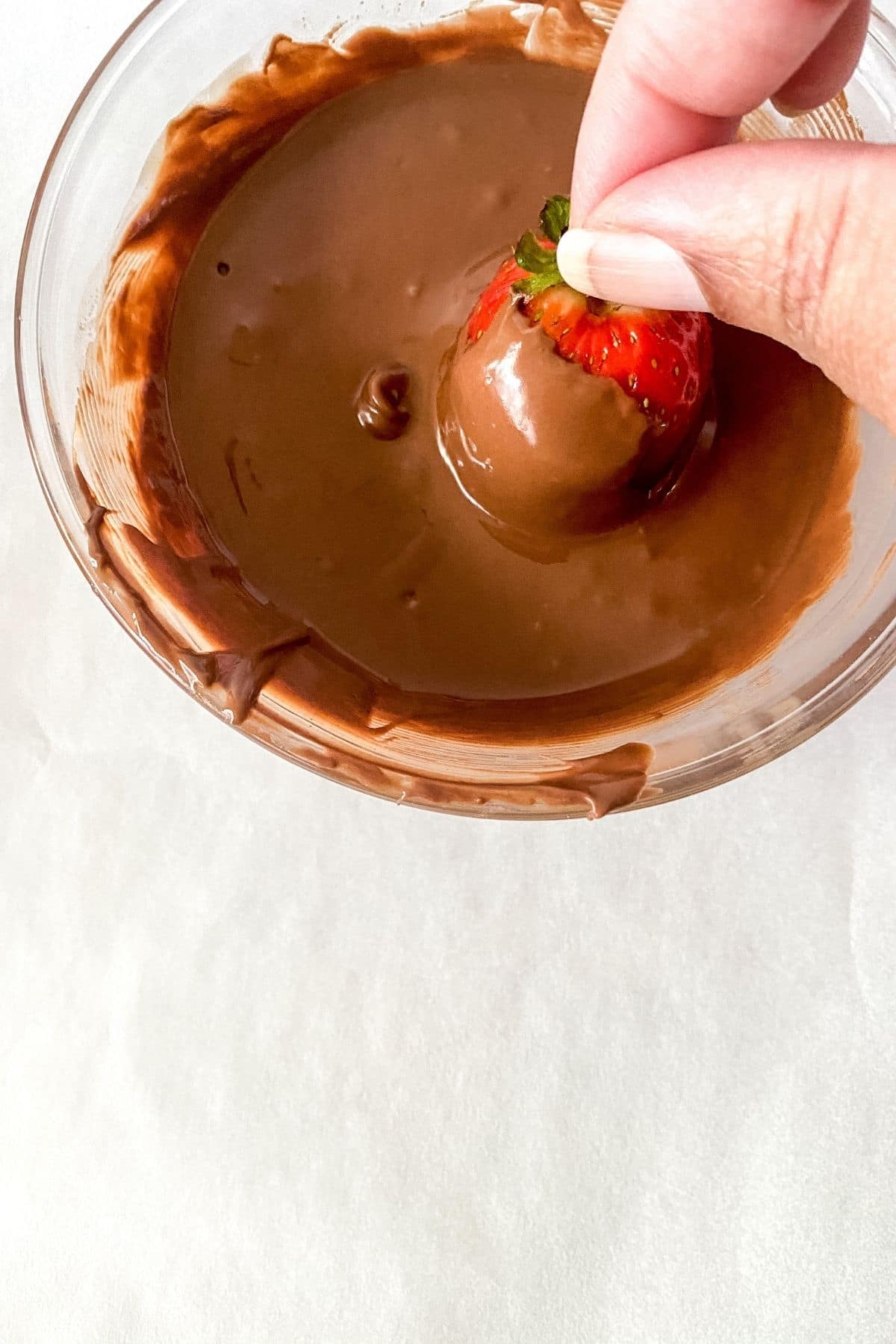 Dipping strawberry in chocolate