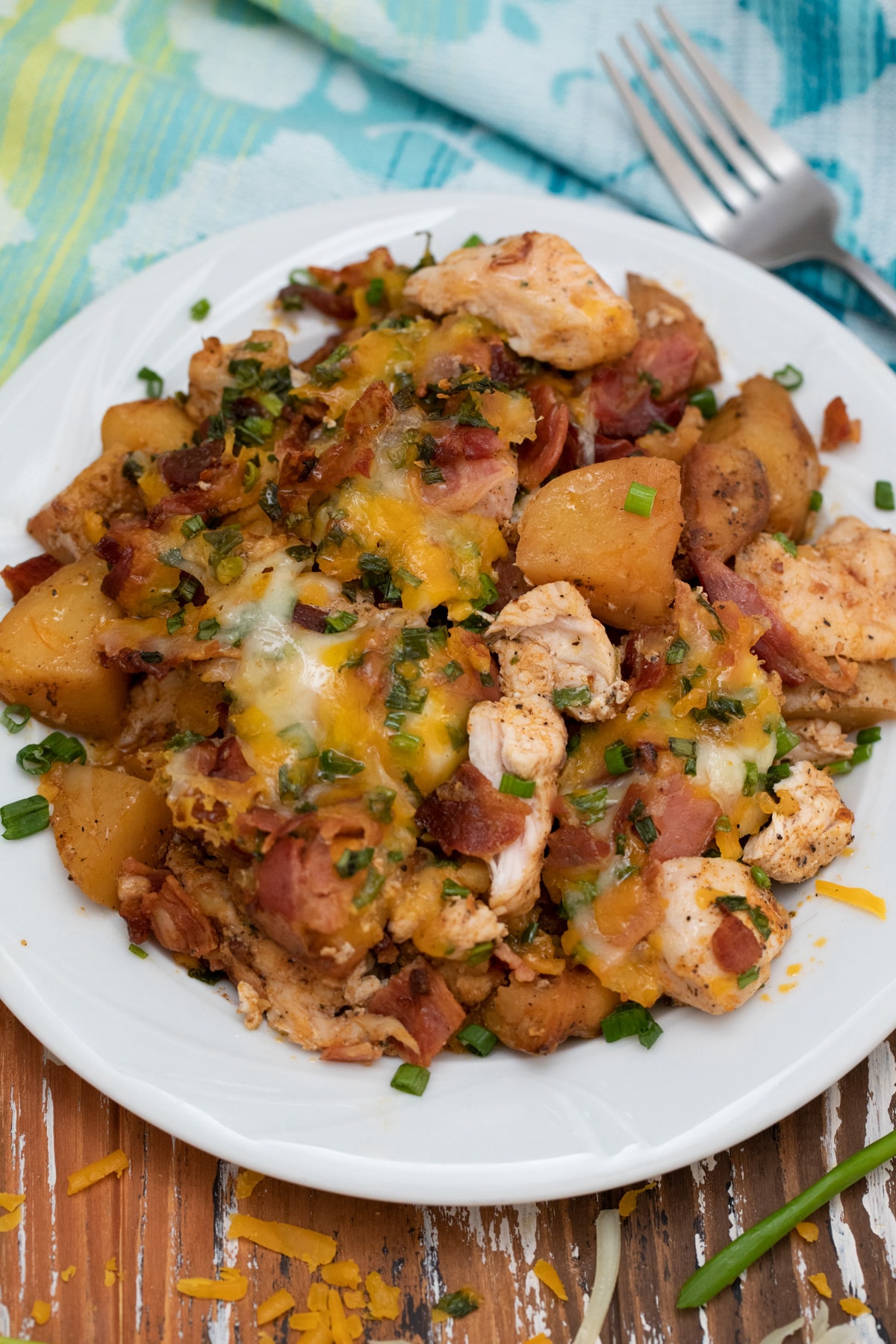 White plate loaded with potato and chicken casserole with cheese and bacon