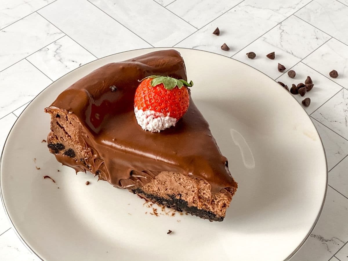 Chocolate cheesecake topped with chocolate ganache and a strawberry