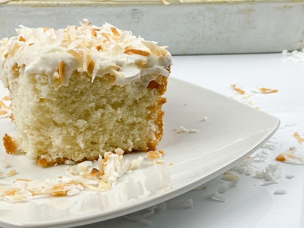 Slice of coconut cake on white plate