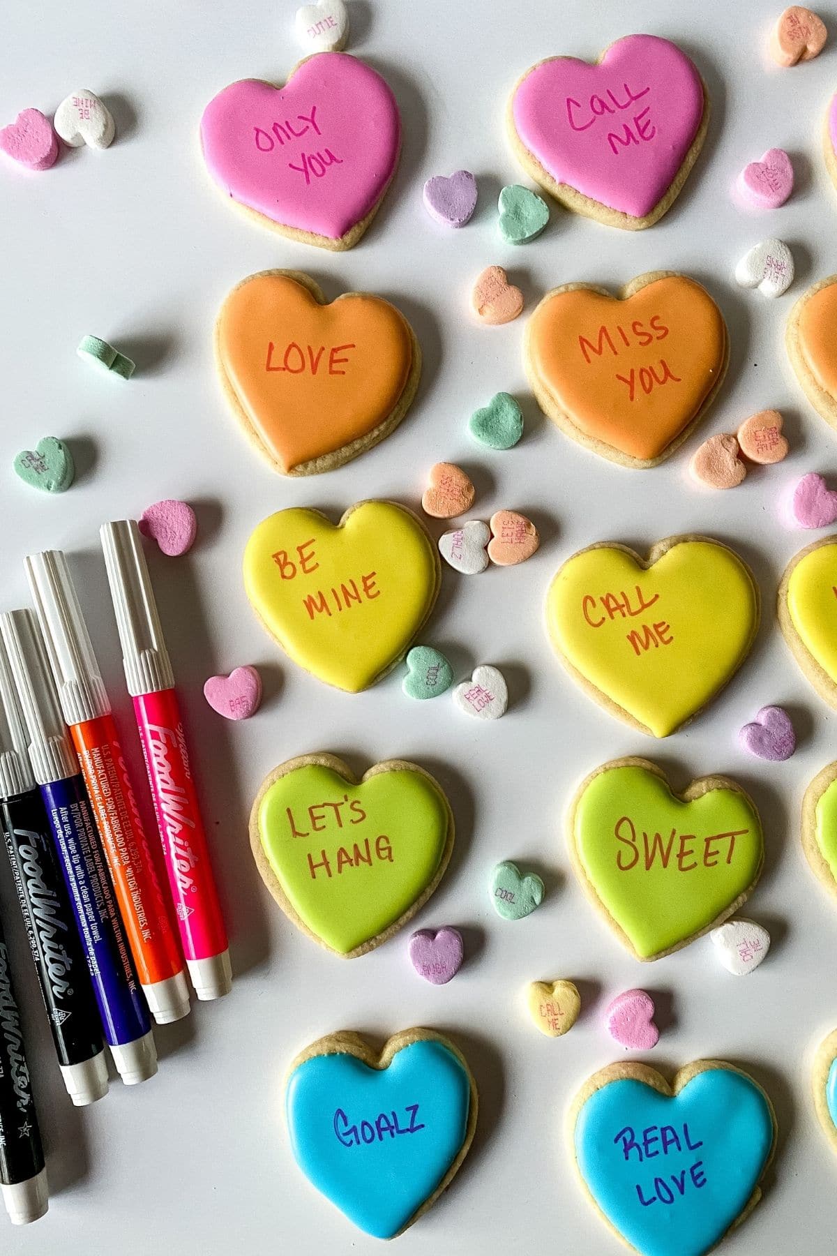 Conversation heart cookies with edible markers on table