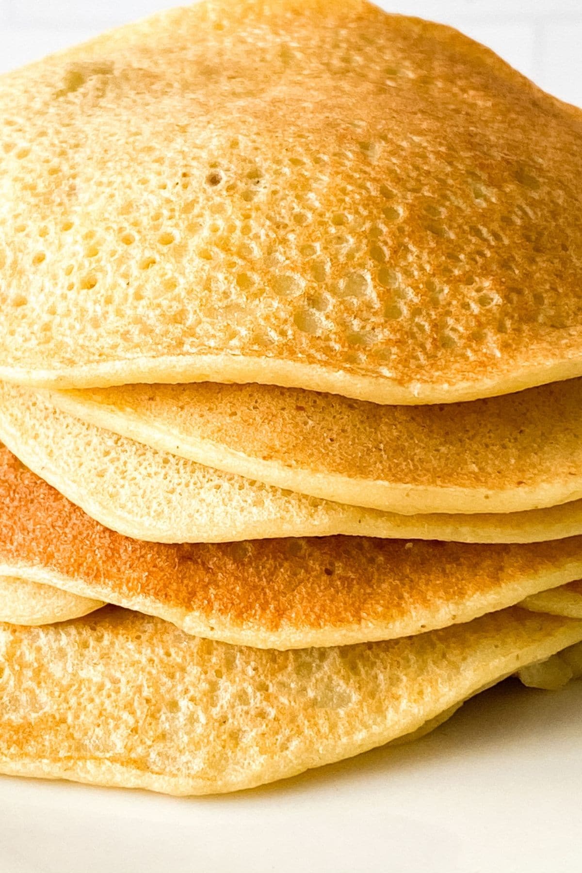 Stack of pancakes on white plate