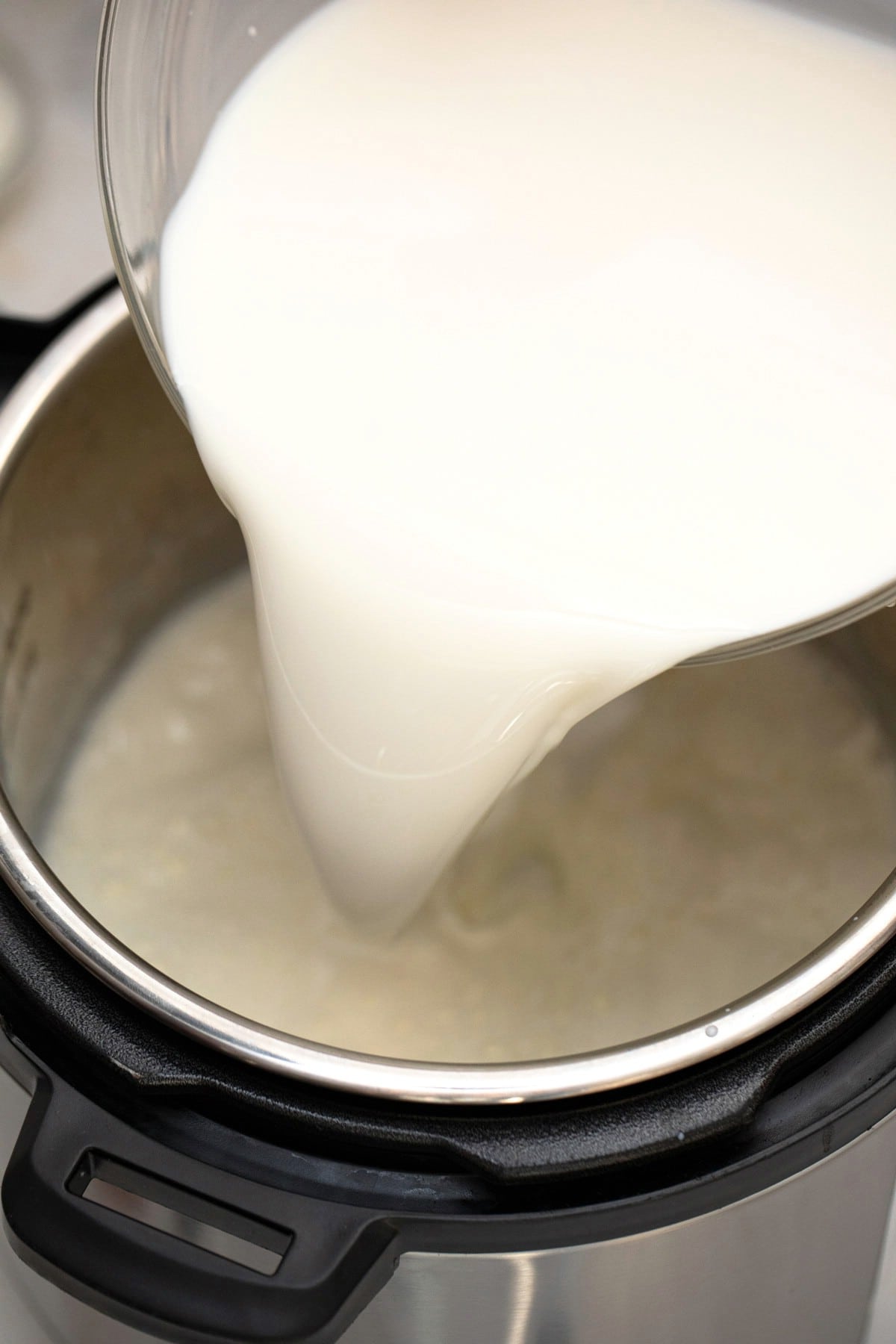 Pouring yogurt into instant pot liner.