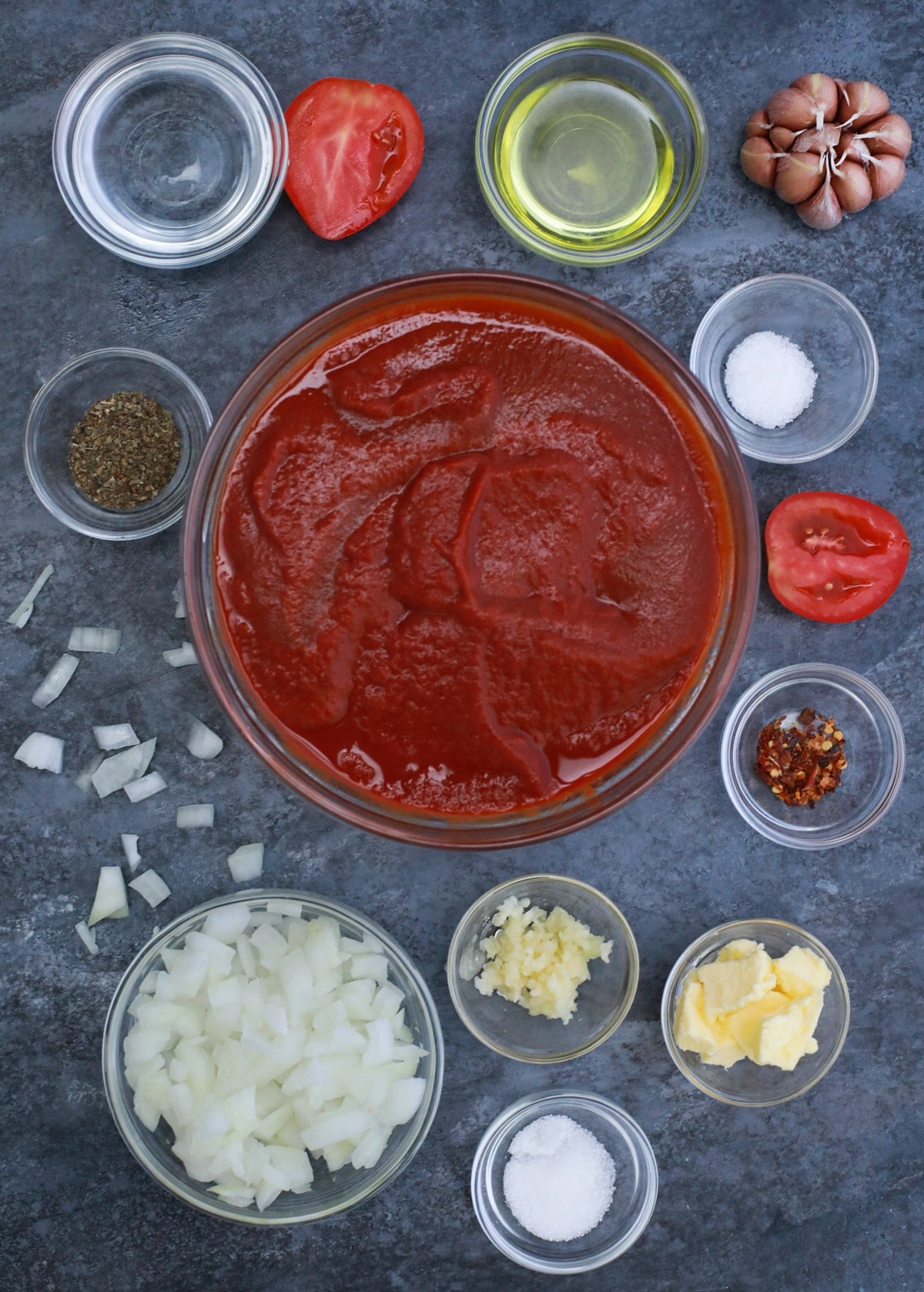 Ingredients for homemade pasta sauce in bowls on blue table