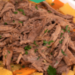 White platter with shredded beef potatoes and carrots