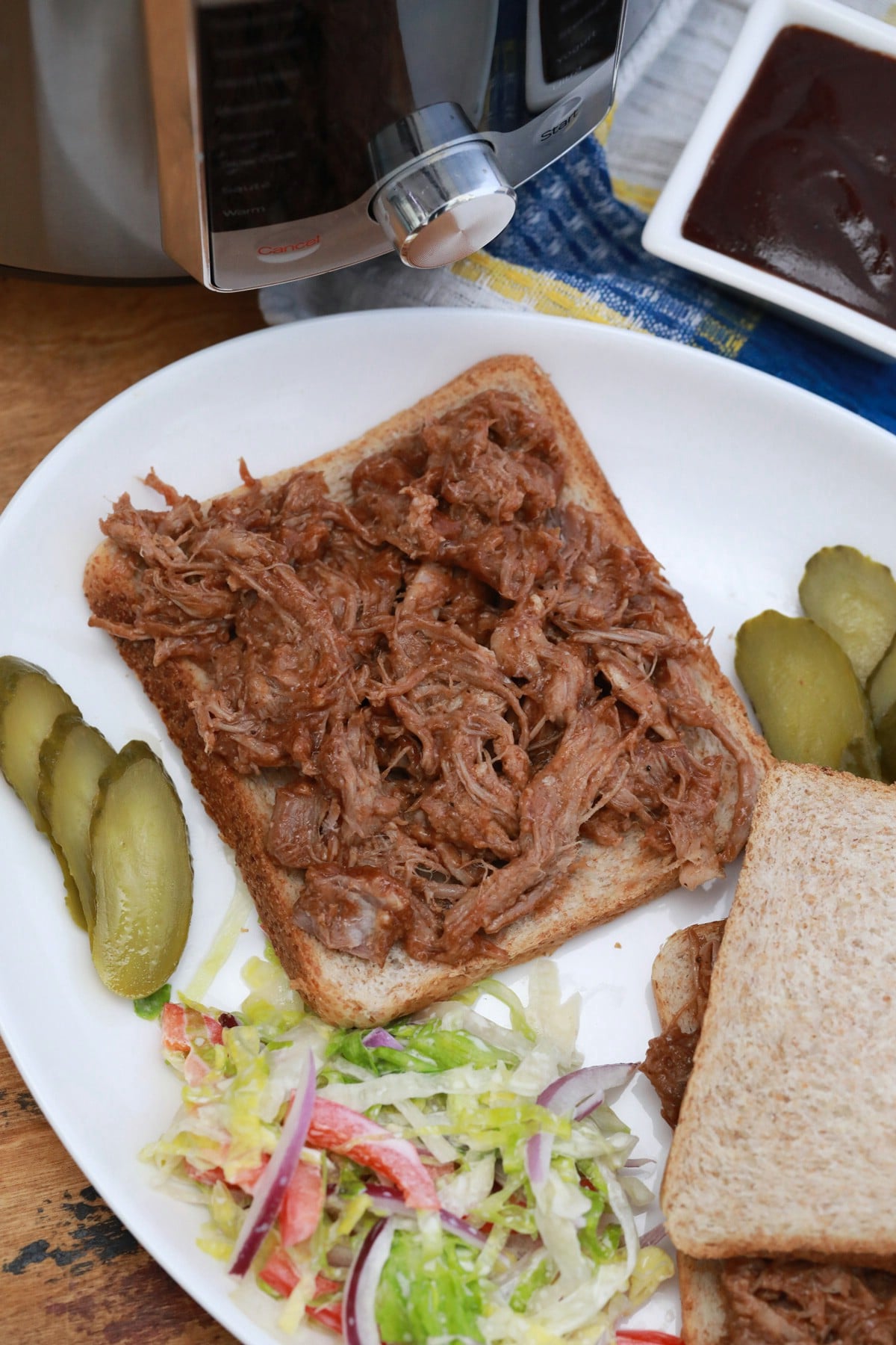 Open faced pulled pork on white plate