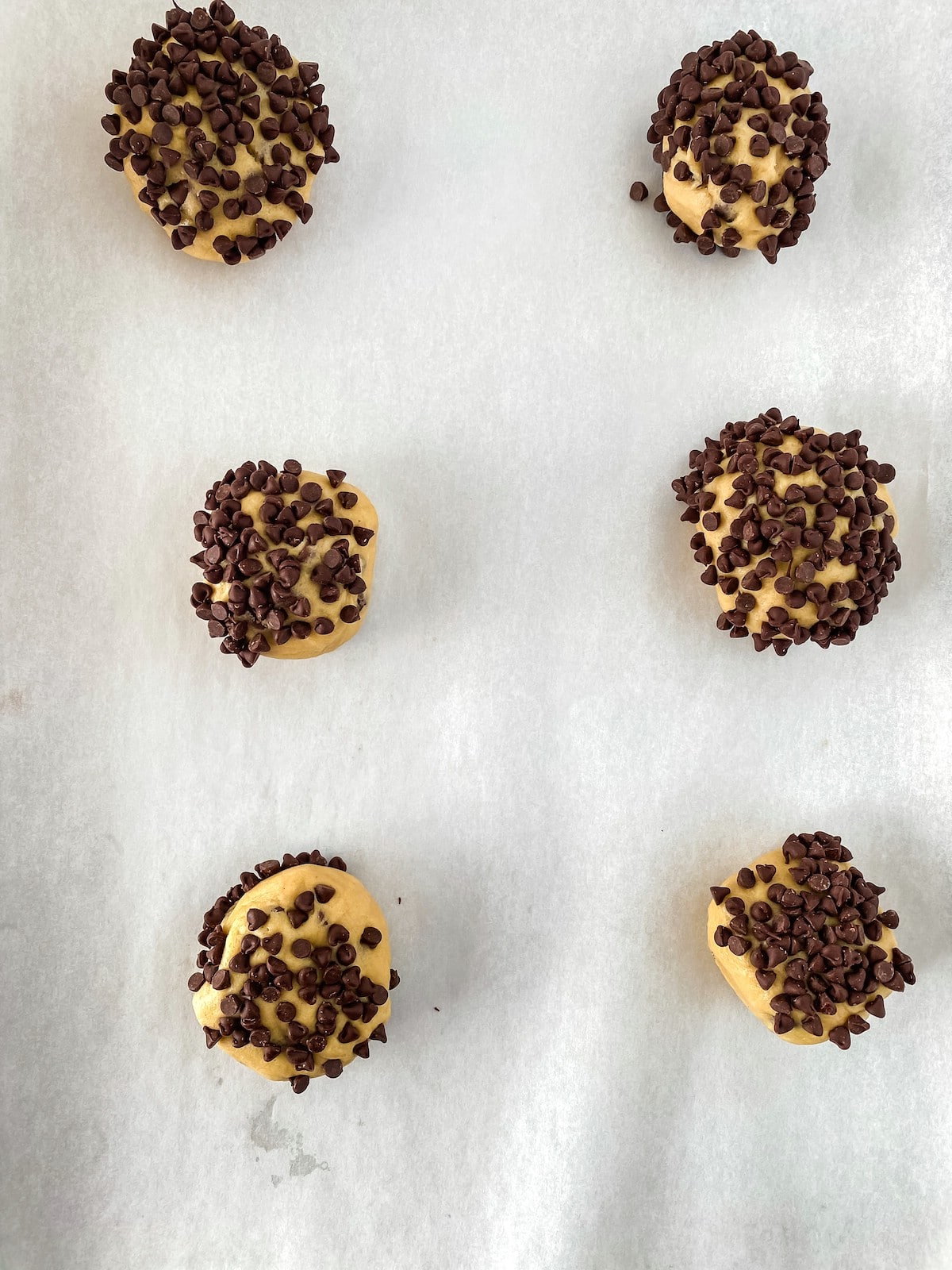 Cookies on baking sheet coated with mini chocolate chips