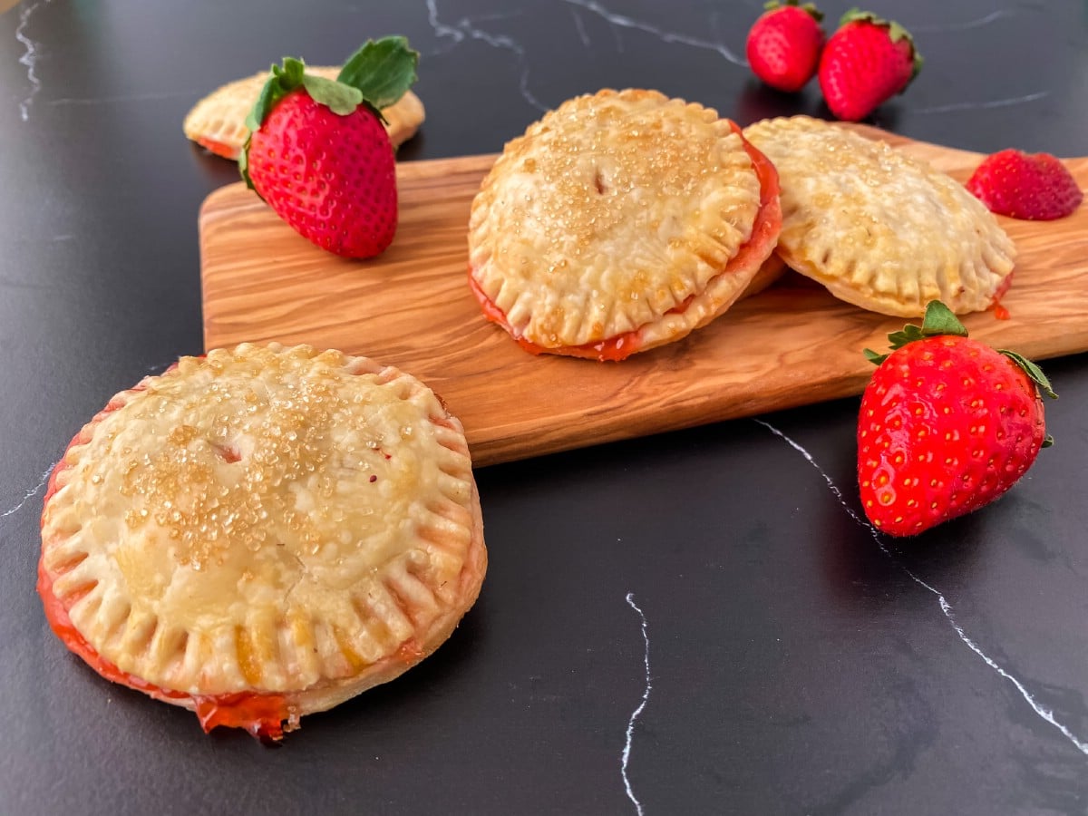 Strawberry hand pies on wooden cutting board 