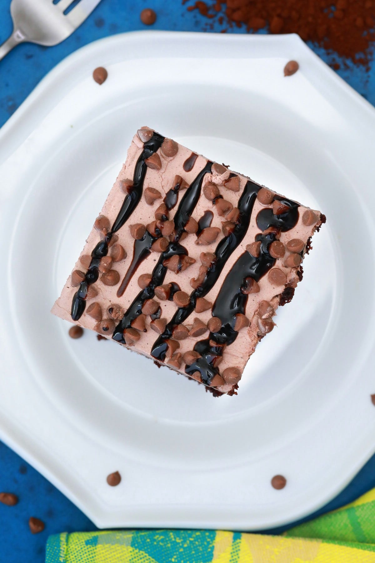 Cake on white plate with chocolate icing and chocolate chips