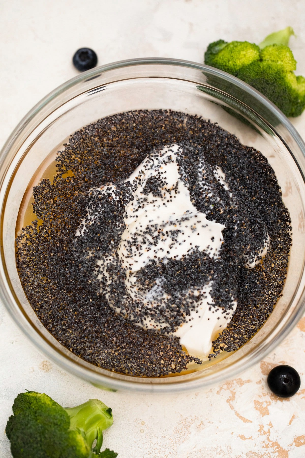 Salad dressing in bowl topped with poppy seeds