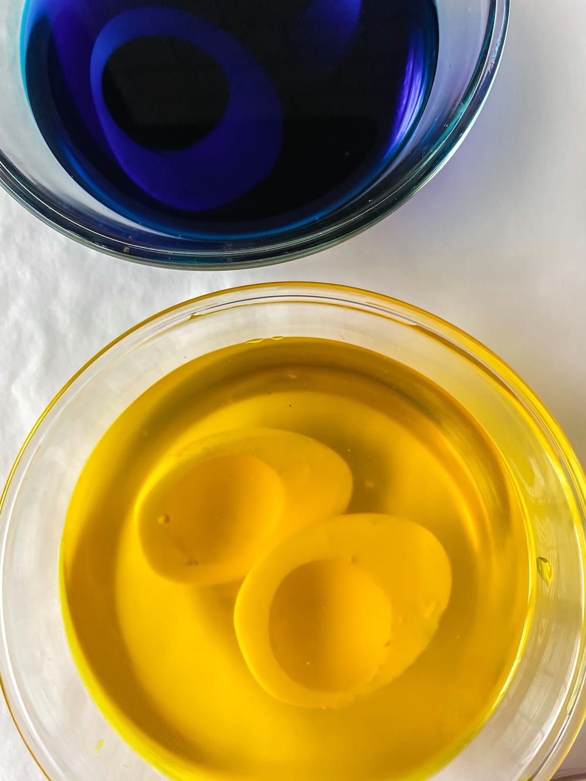 Eggs in bowls with blue and yellow dye