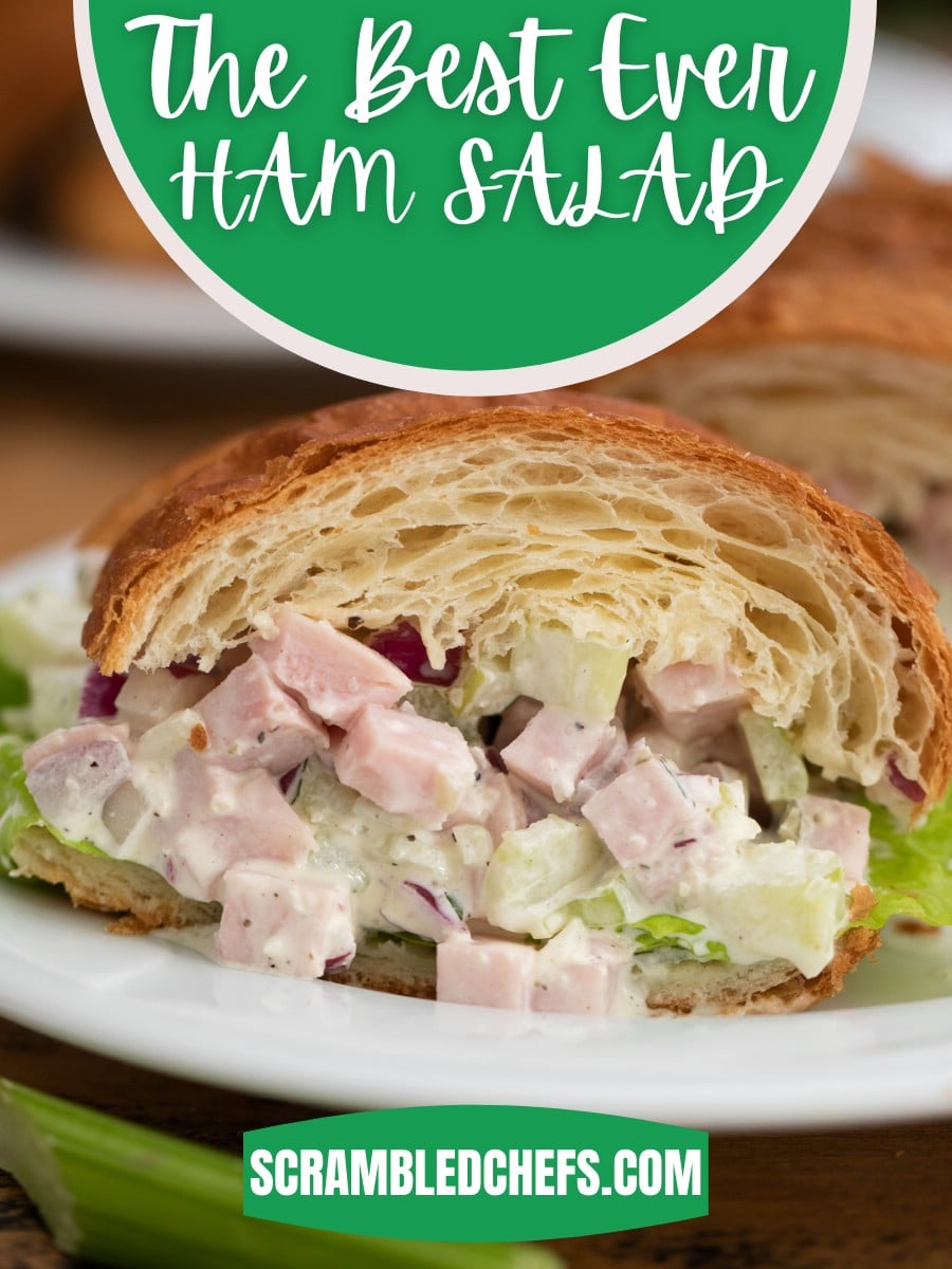 Slice of ham salad sandwich on croissant on white plate