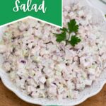 White bowl filled with ham salad topped with parsley